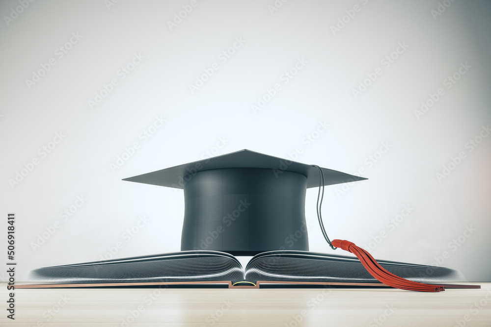 Higher education and study concept with black mortarboard hat on opened book on light background. 3D