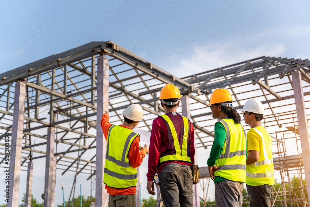 Asian Contractor with workers and Steel roof structure under construction background. Teamwork Conce