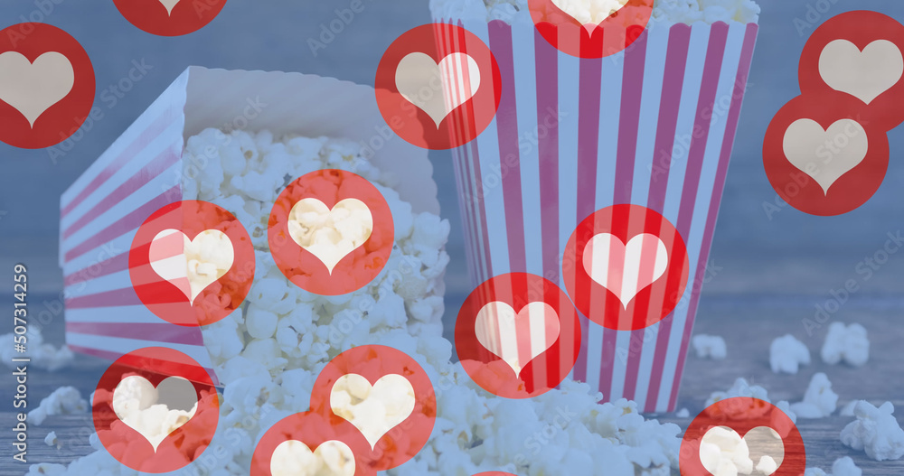 Image of heart icons flying over popcorn in red and white striped tubs