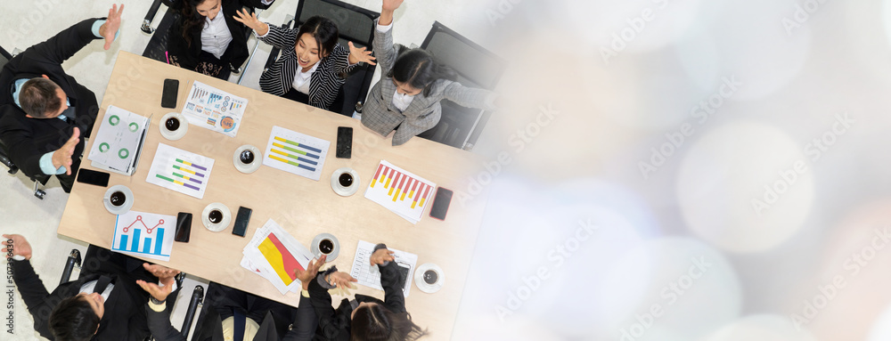 Successful business people celebrate together with joy at office table shot from top view . Young bu