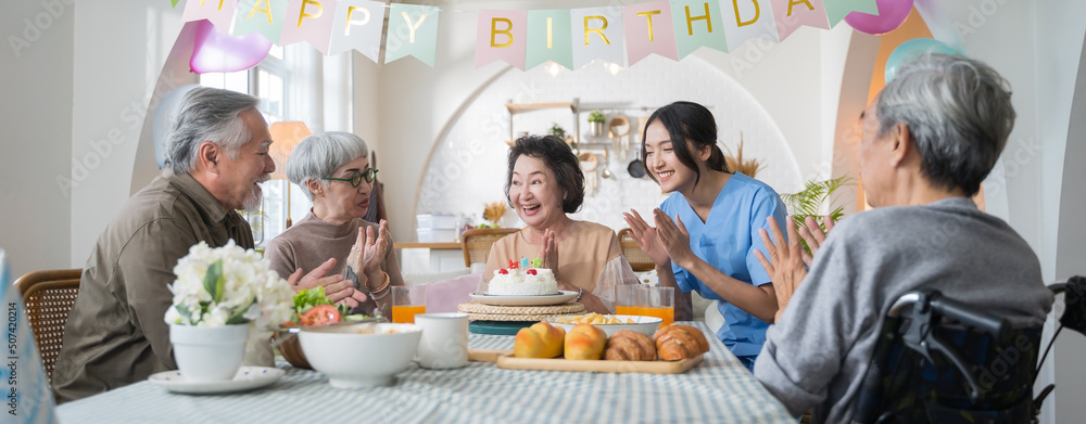 一群亚洲老年人在家举办生日派对，在养老院庆祝生日