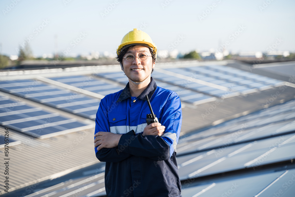 亚洲工程师在屋顶光伏太阳能电池板背景场上的肖像