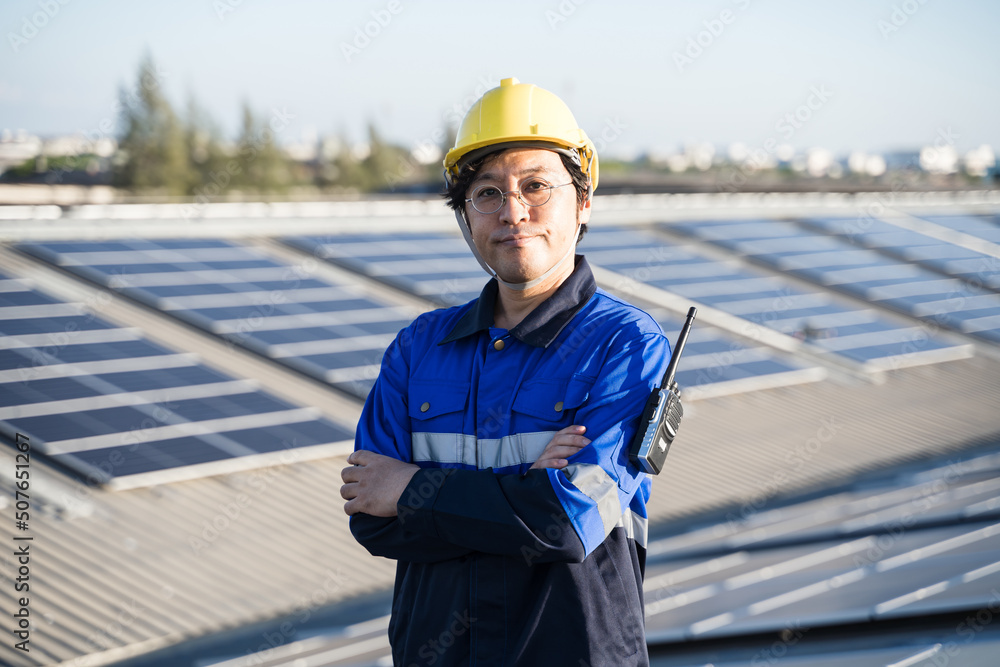 亚洲工程师在屋顶光伏太阳能电池板背景场上的肖像