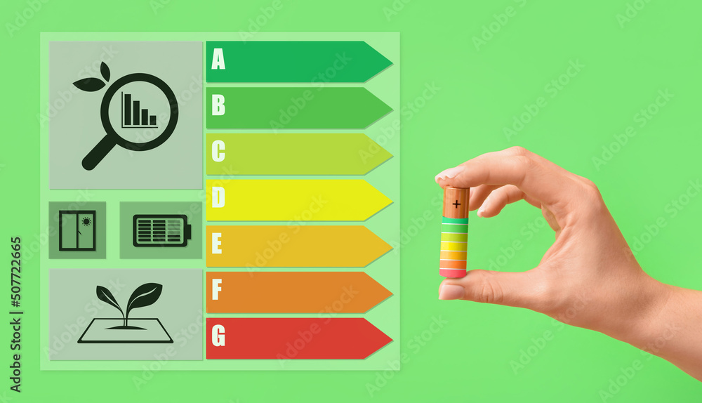 Woman holding lithium battery on green background. Concept of energy efficiency