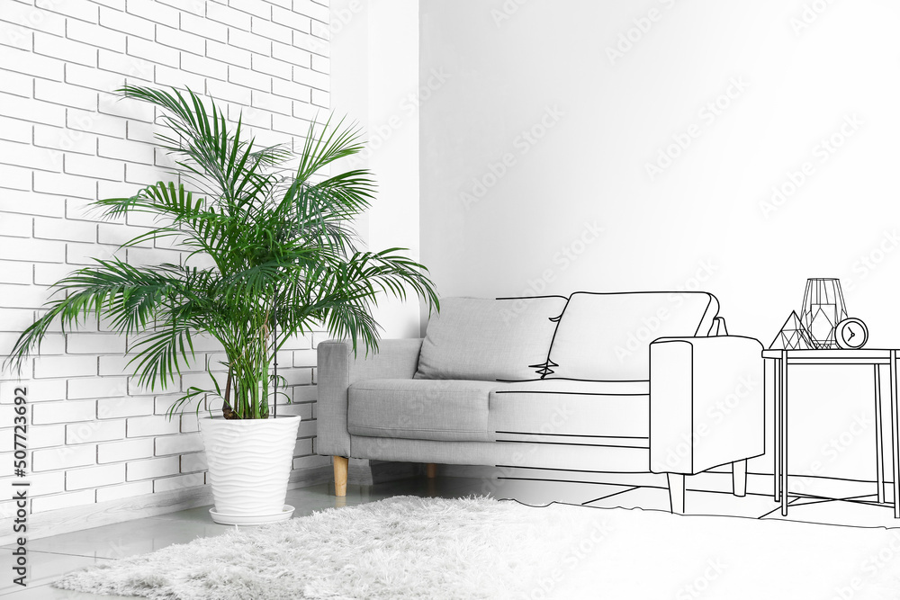 Interior of light living room with grey sofa, table and palm tree