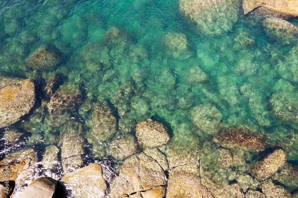 Aerial view Top down seashore wave crashing on rock cliff Beautiful blue sea surface in sunny day su