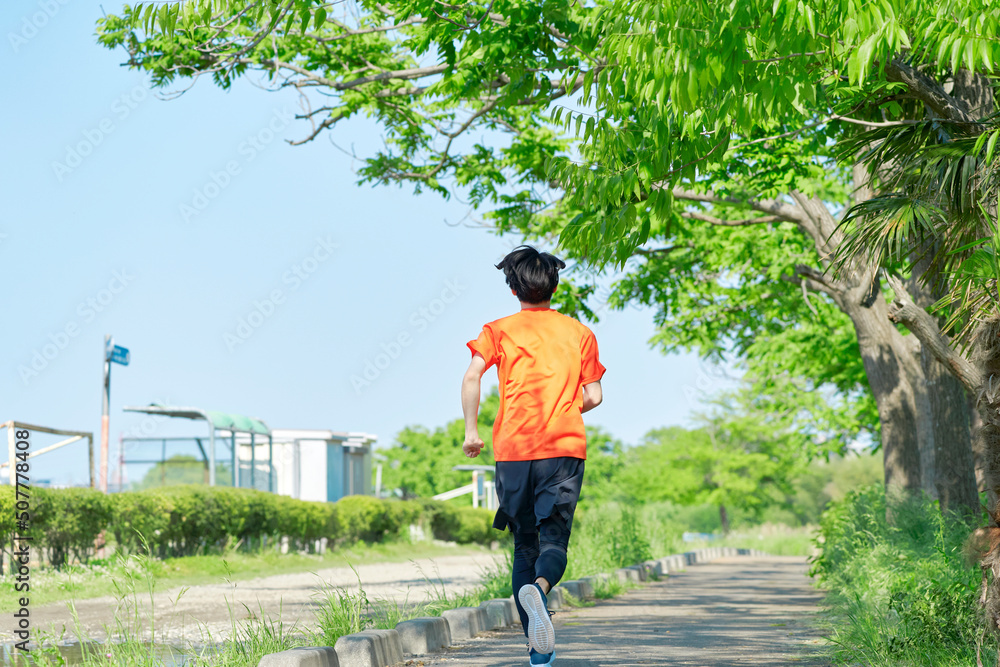 屋外でジョギングする男性後ろ姿　全身