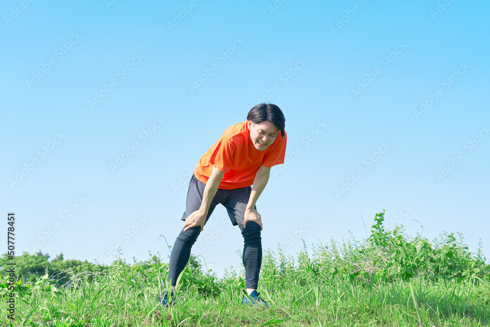 屋外で運動して疲れている男性