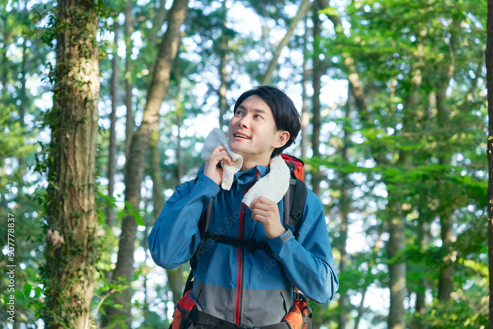 タオルで汗を拭く登山する男性