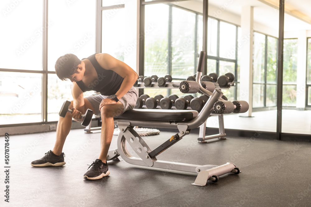 Man exercise with dumbell lifting bicept alone in fitness