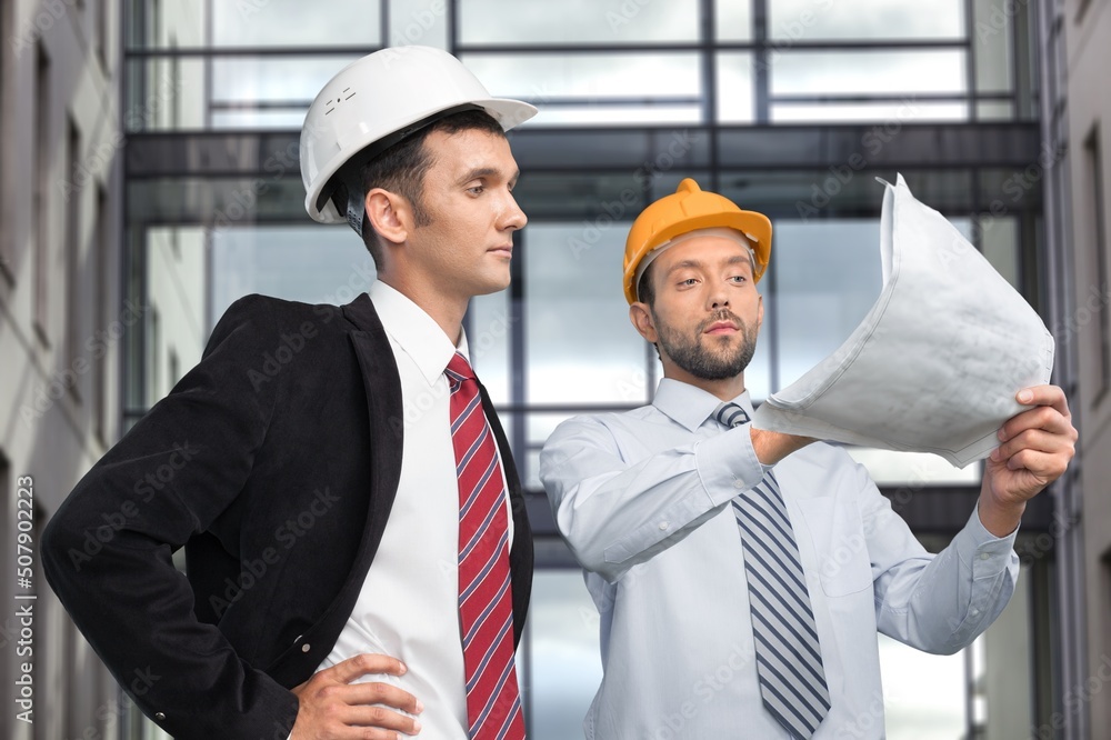 Manual worker and engineer discussing on plan.  Architect supervisor meeting at construction site.