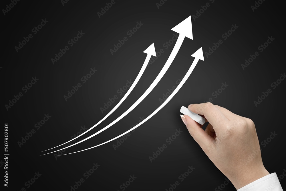 hand with chalk on a blackboard draws a graph of growing inflation, statistics infographics concept