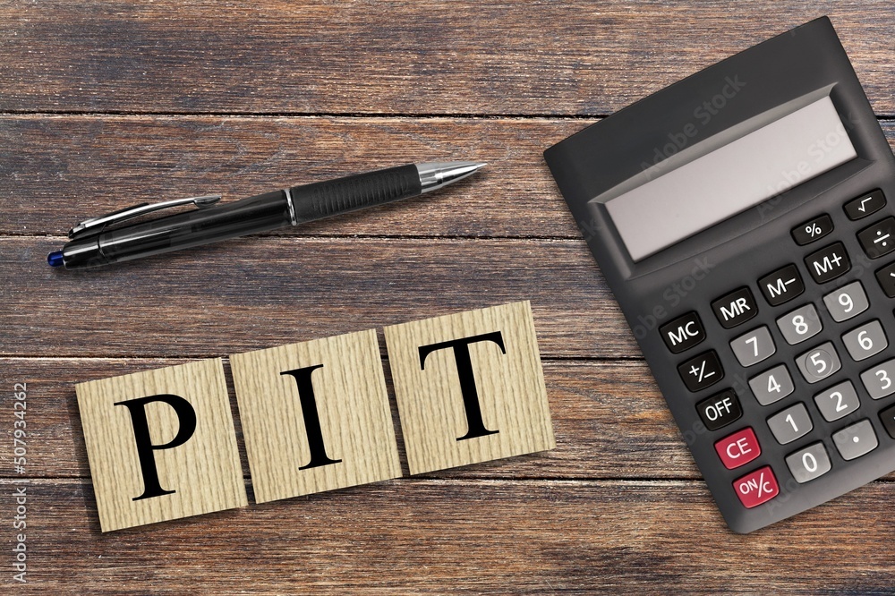 Business hand working. Wooden blocks for text, abbreviation indicating personal income tax