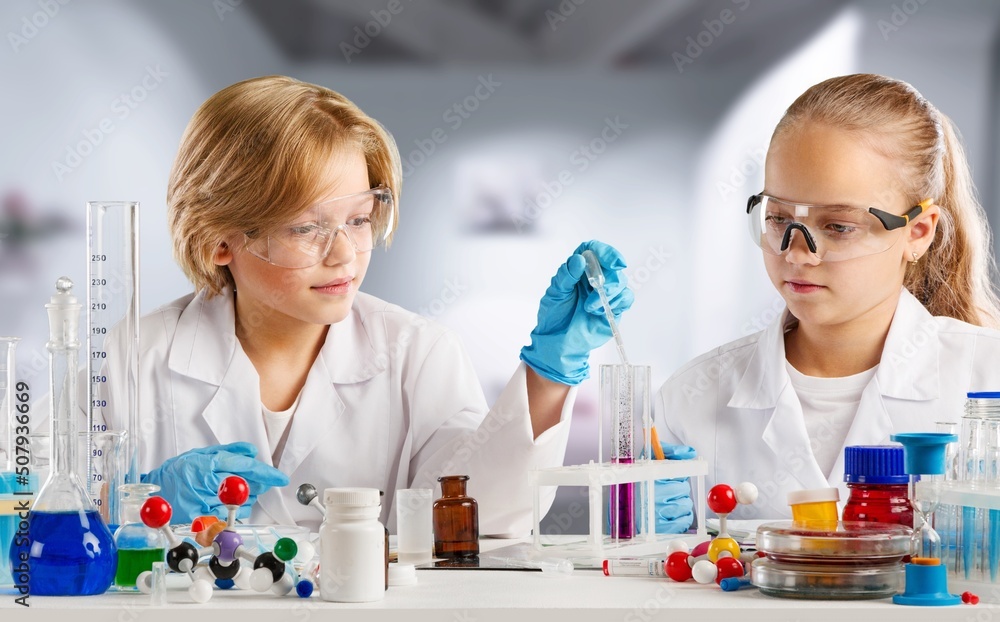 Excited Kid conducting a scientific experiment  or chemical reaction at chemistry laboratory