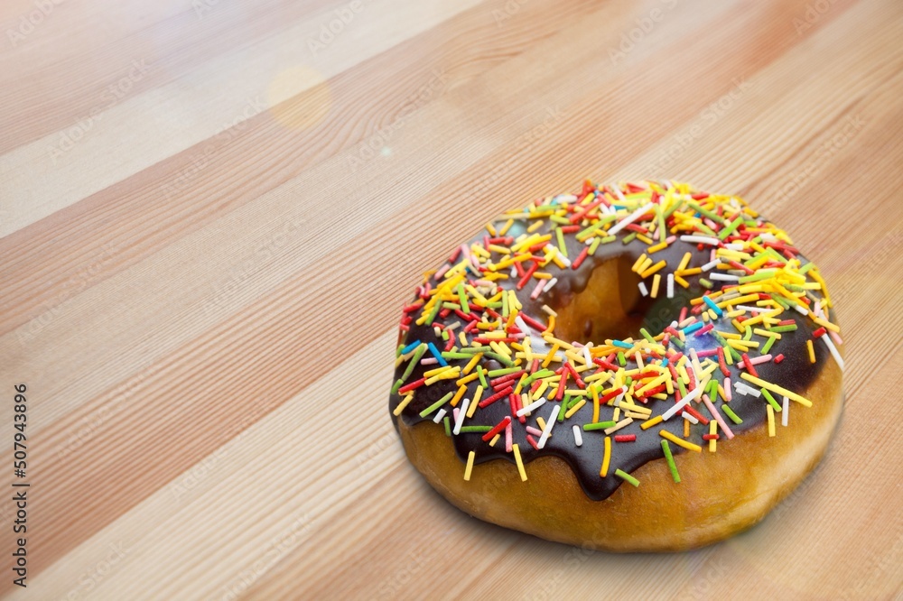 Tasty sweet chocolate glazed donut with crumbs and creme filled