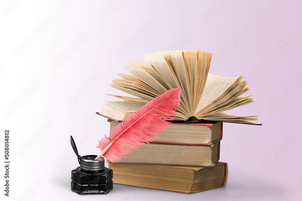 Stack of old  antique books, inkwell with quill pen.