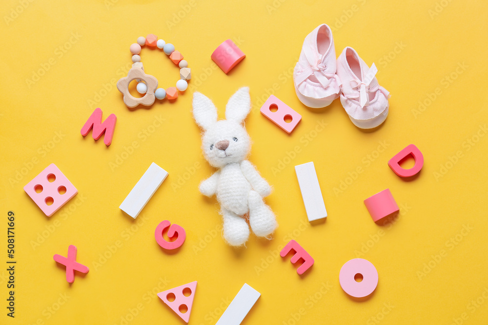 Children toys with booties on yellow background