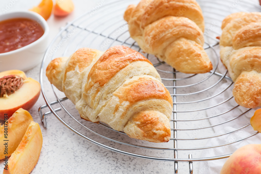 Grid of delicious croissants with peach jam on white background