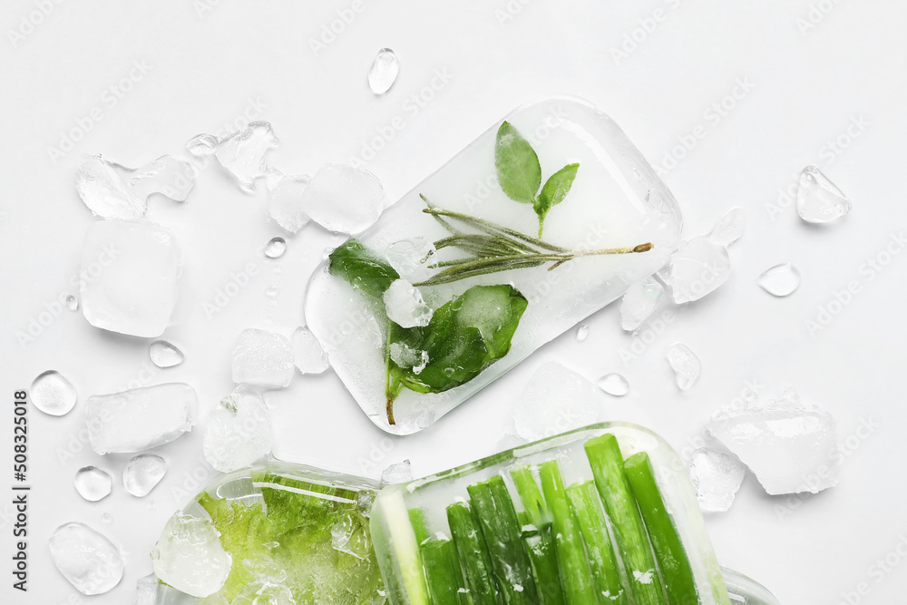 Fresh greens frozen in ice on light background