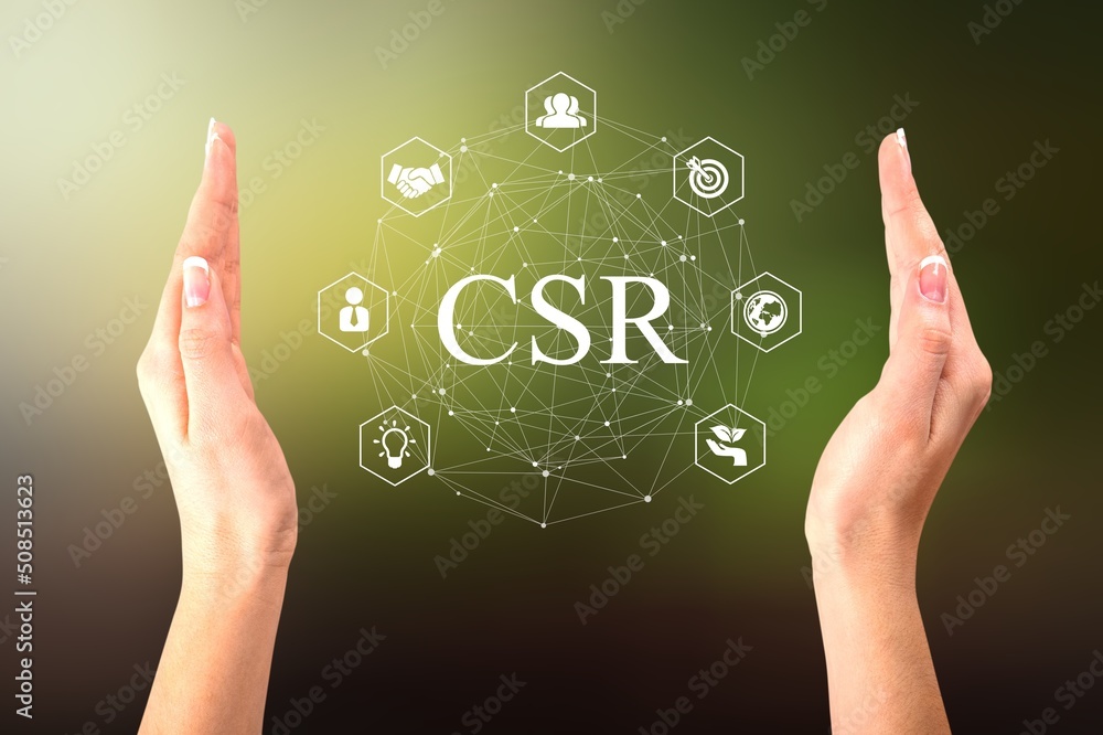 Business hand with organization CSR icon on a green nature background.