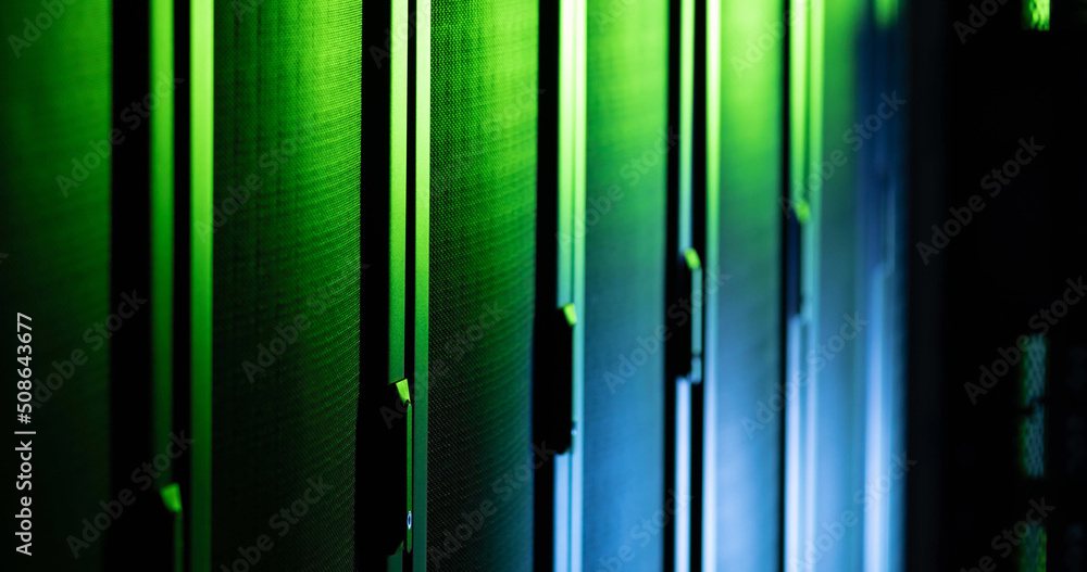 Image of close up of empty corridor with row of blue and green computer servers