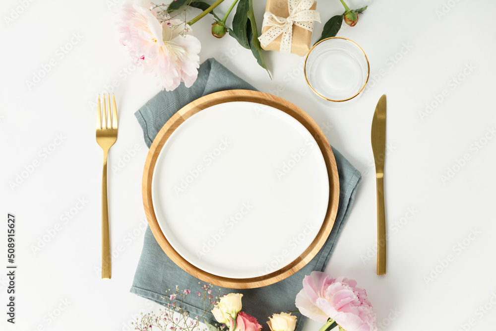 Beautiful table setting with golden cutlery and peony flowers, mock up