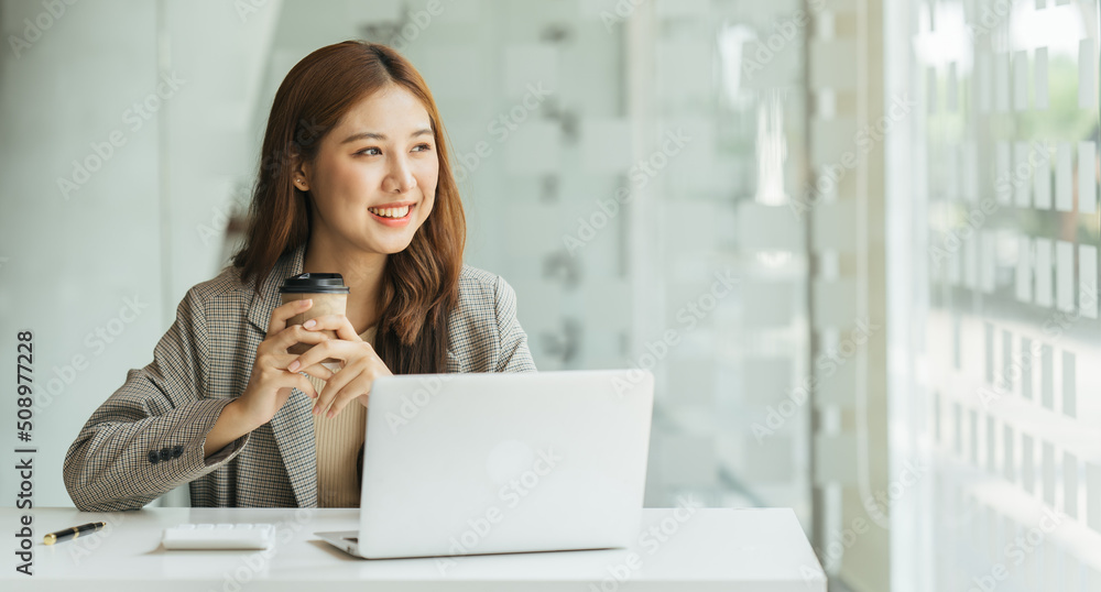 Young beautiful woman using her laptop while sitting in a chair at her working place,  Small busines