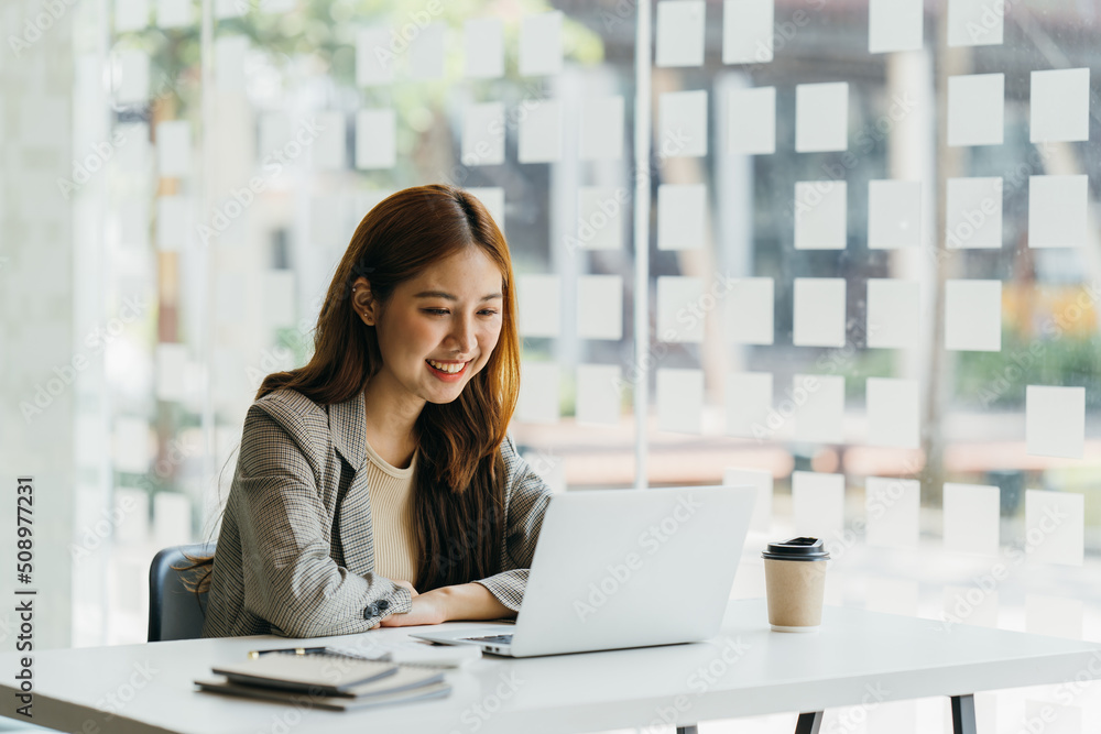 Young beautiful woman using her laptop while sitting in a chair at her working place,  Small busines