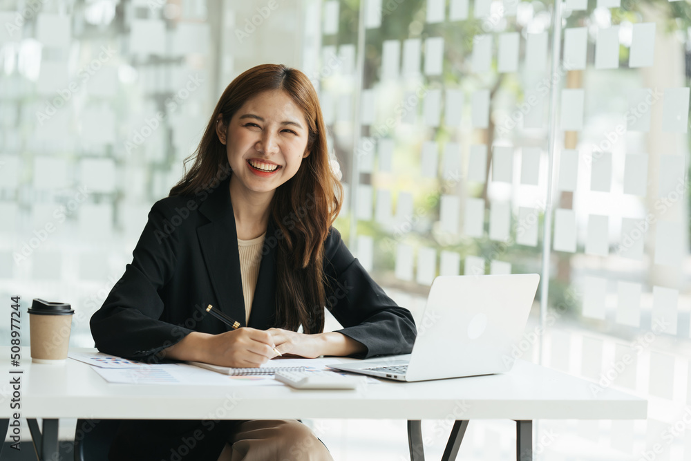 Young beautiful woman using her laptop while sitting in a chair at her working place,  Small busines