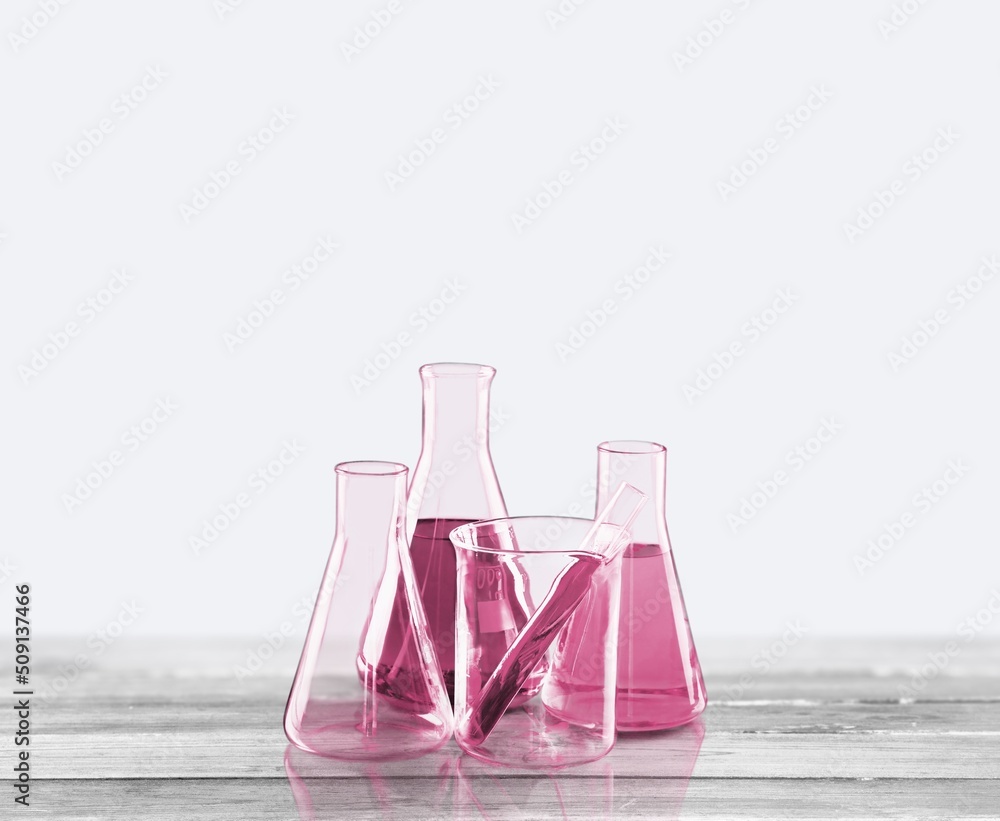 Glass laboratory equipment filled with fluid in a beaker test tube in lab background for experiment 