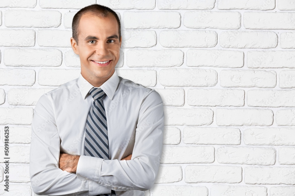 Portrait of smiling mature man standing and posing on background.