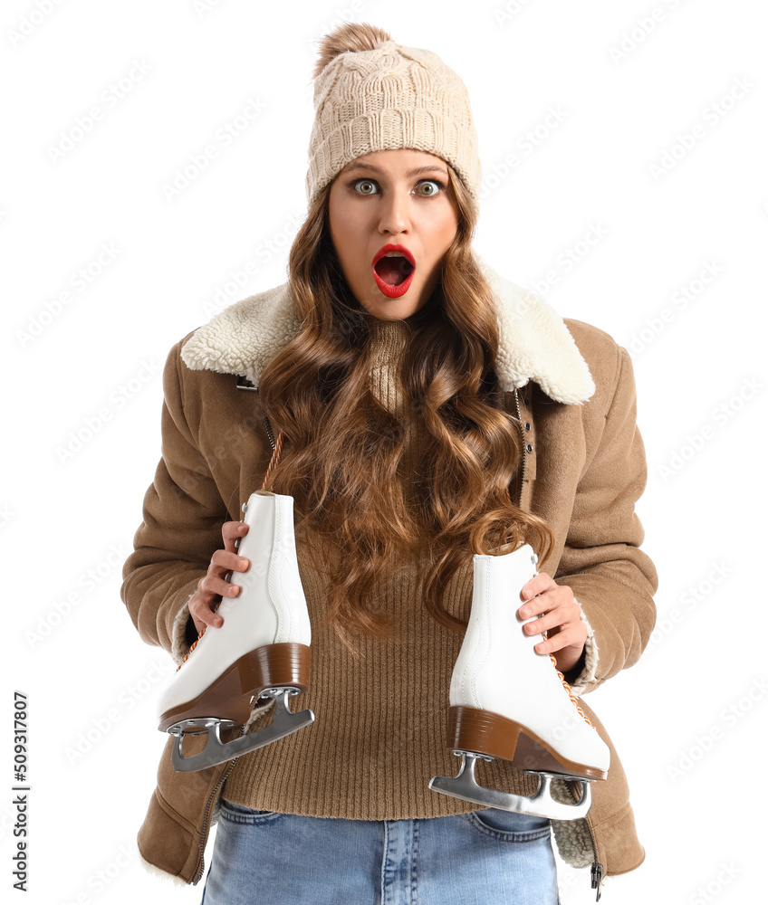 Beautiful surprised young woman with ice skates isolated on white