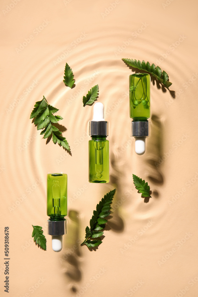 Bottles with natural serum and fern leaves in water on color background