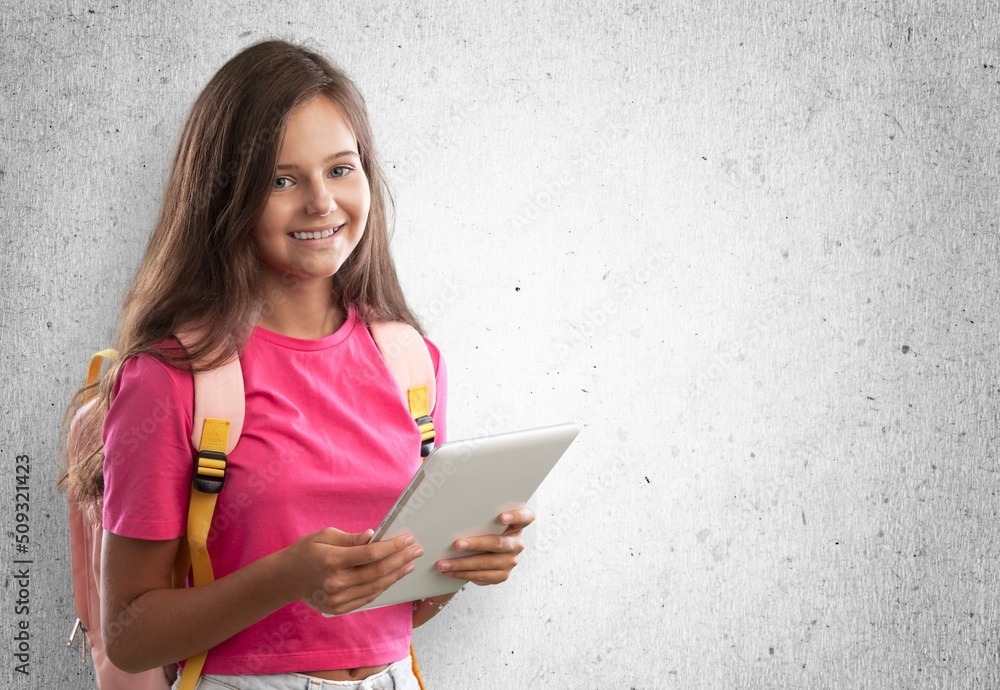 Cute little child with school bag and holds a book.