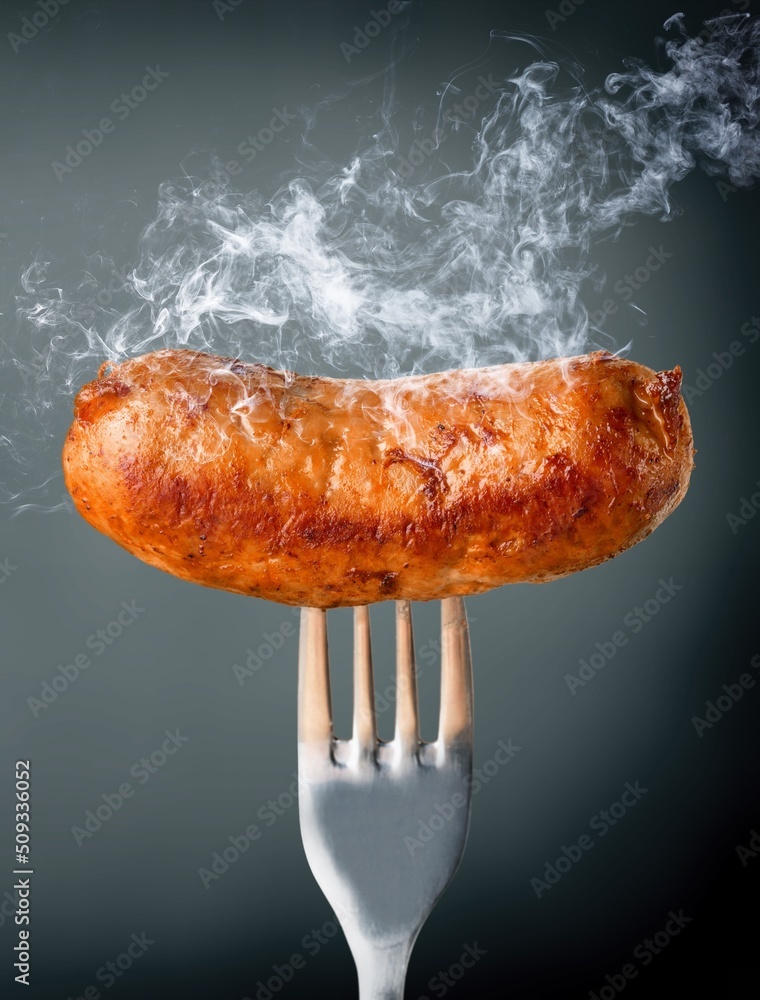 Big fried hot thinking sausages on a fork. Grilled sausage concept.