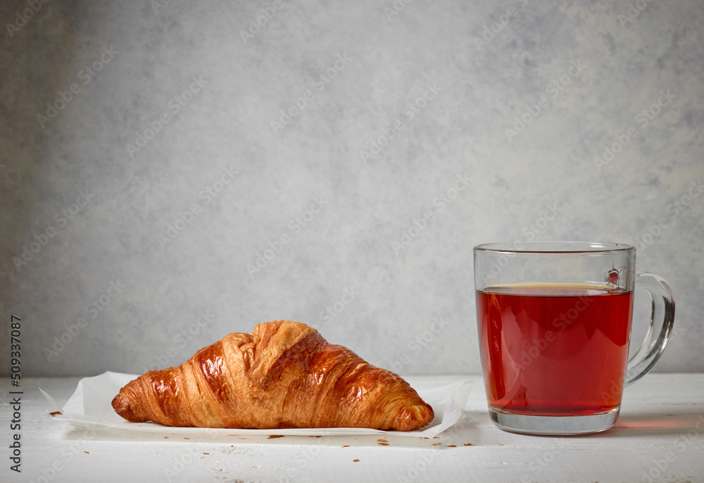 close up of tea cup and croissant