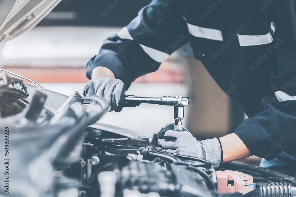 Mechanic works on the engine of the car in the garage. Repair se