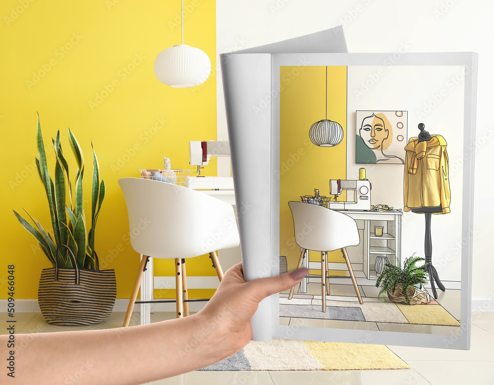 Female designer holding sketchbook with new interior of her office