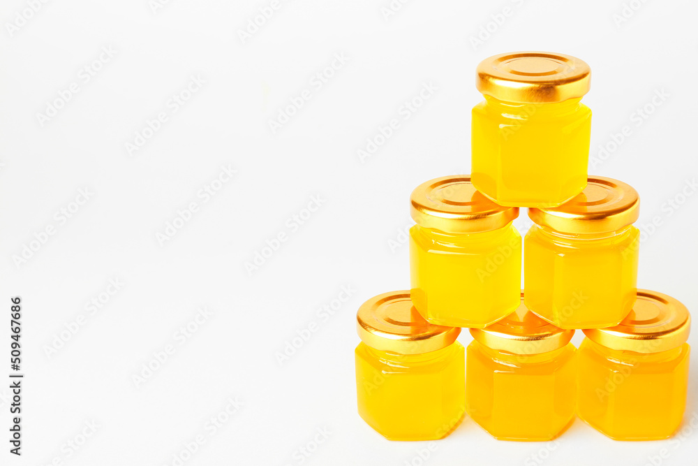 Jars with honey on white background