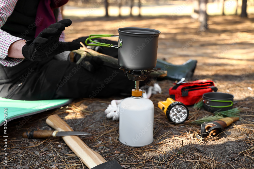 Male tourist cooking food in forest