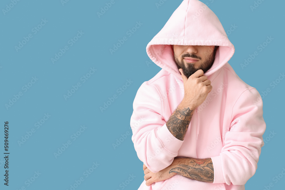 Bearded man wearing hoodie on blue background