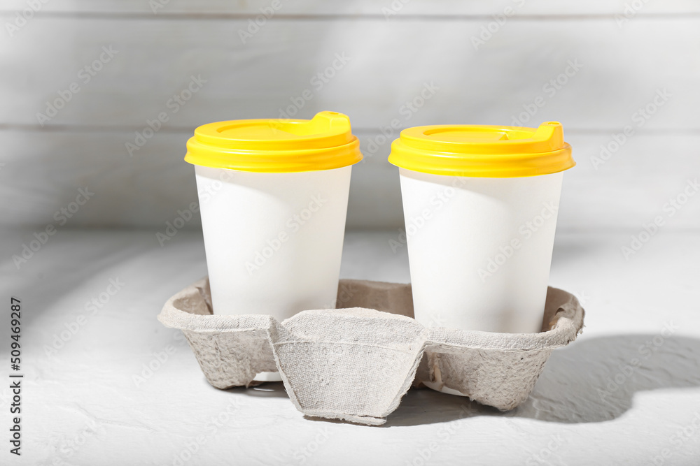 Holder with takeaway paper cups on table