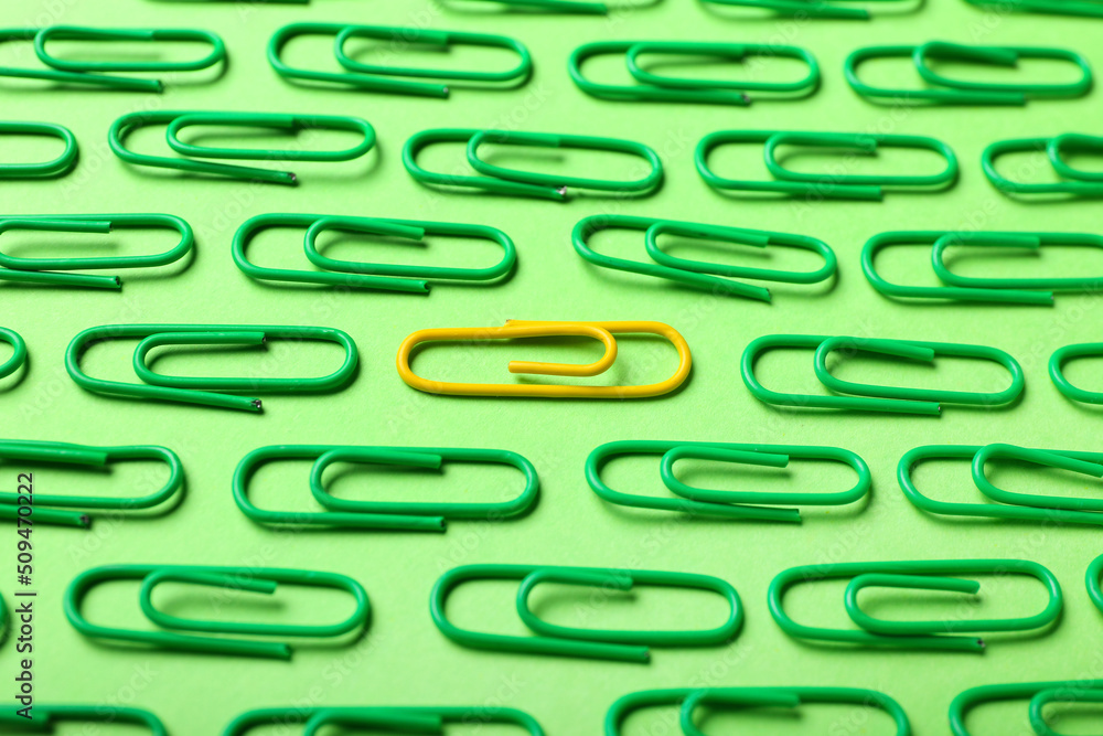 Yellow and green paper clips on color background