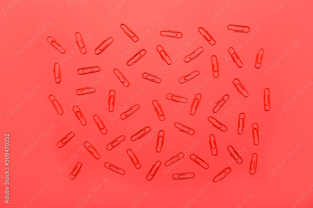 Paper clips on red background