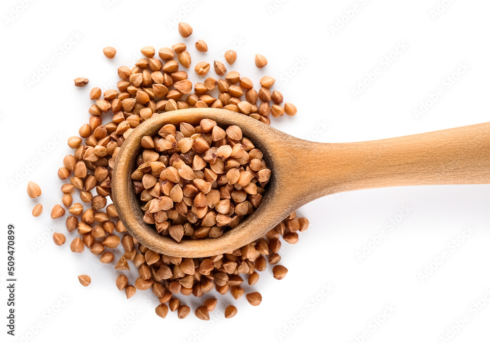 Wooden spoon with buckwheat on white background, closeup