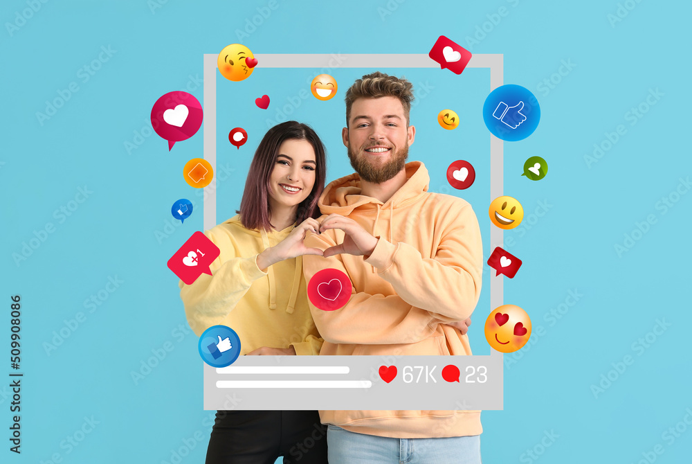 Happy young bloggers showing heart shape with their hands on blue background