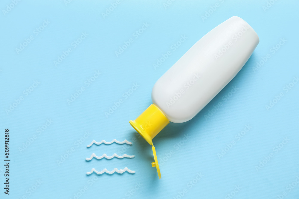 Bottle of sunscreen on blue background