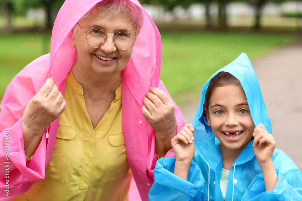 小女孩和她的奶奶在户外穿着雨衣