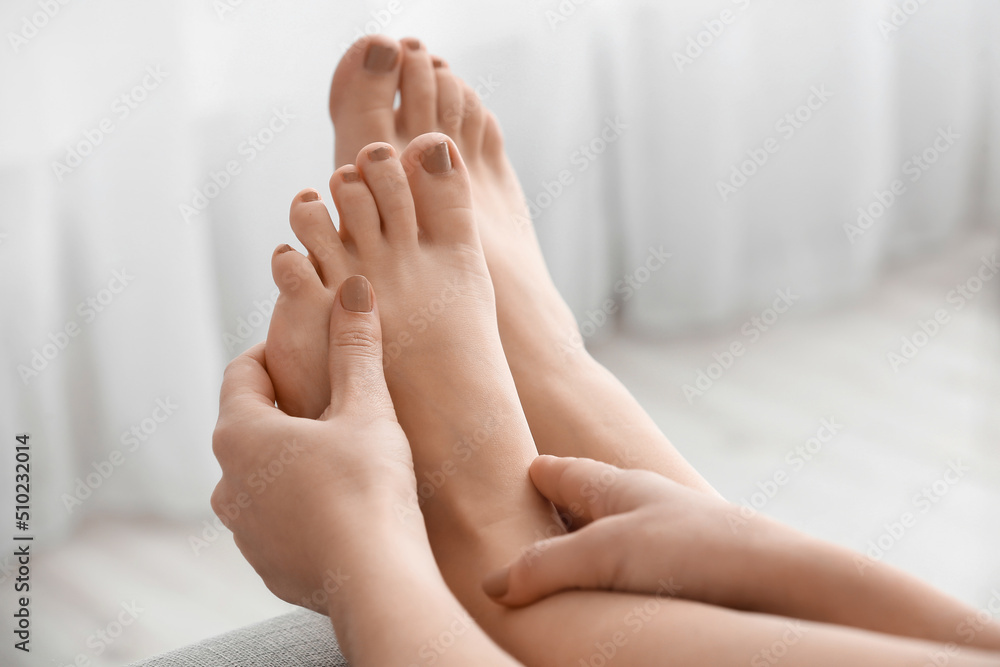 Young woman making foot massage indoors, closeup