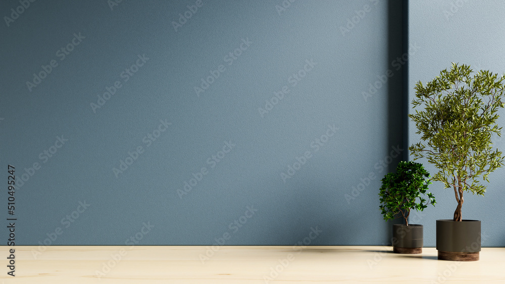 Plants on a wooden floor in empty dark blue room.